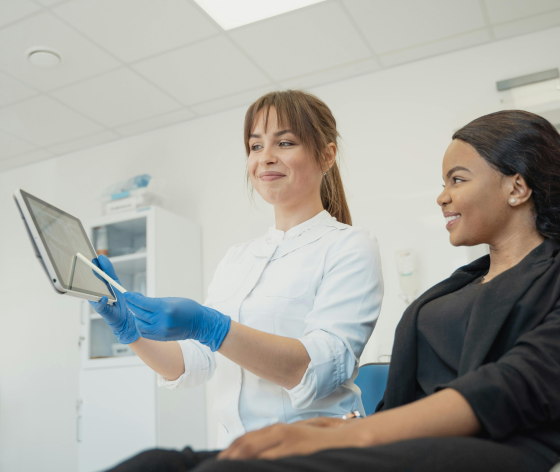 Doctor showing health information on a tablet to a smiling patient.